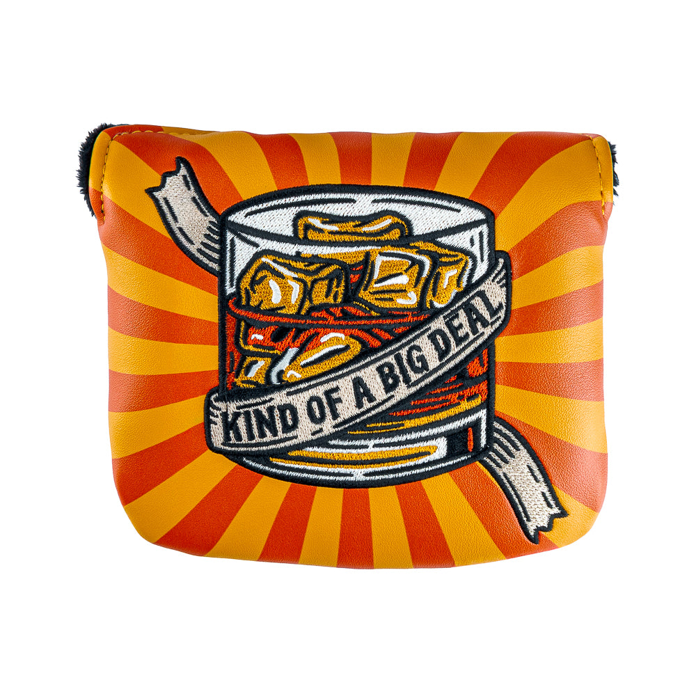Rewind Golf x Anchorman mallet golf headcover with a graphic design of a glass of whiskey with 'Kind of a Big Deal' text on an orange and red striped UV material.